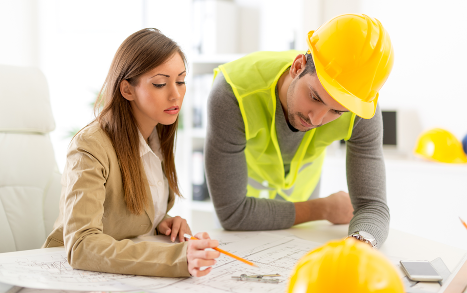 Mujer y hombre trabajando juntos en una oficina, representando el trabajo en equipo y la seguridad en el lugar de trabajo